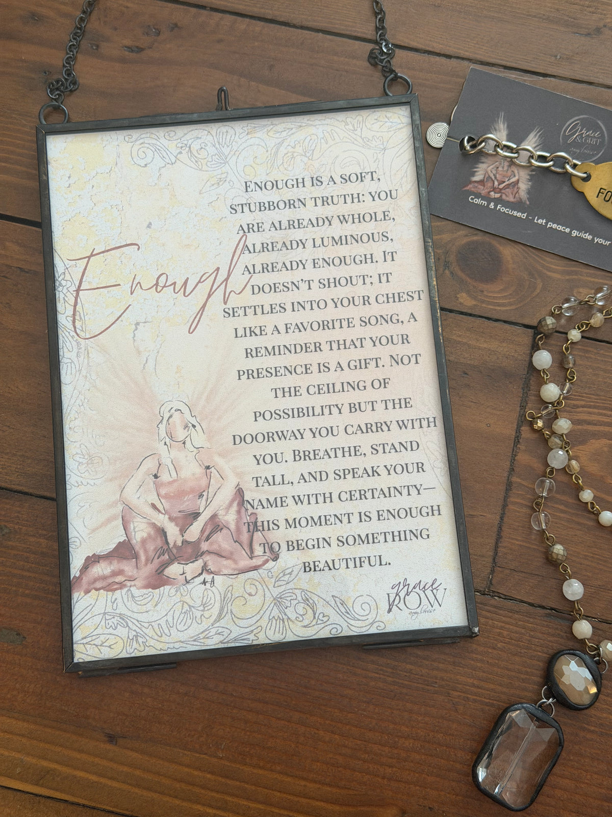Decorative plaque with text and artistic design on a wooden surface