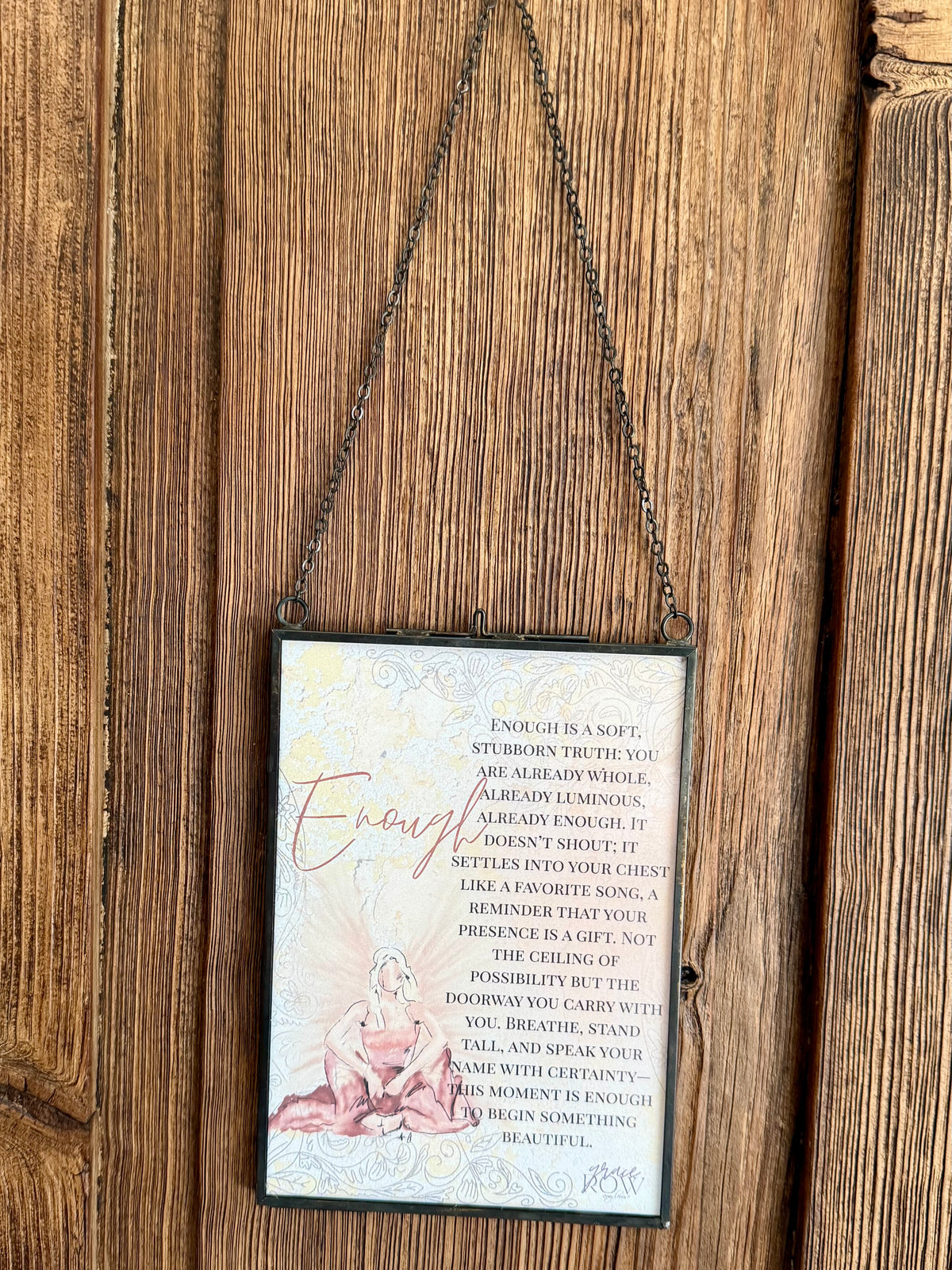 Decorative sign with text and illustration hanging on a wooden wall.