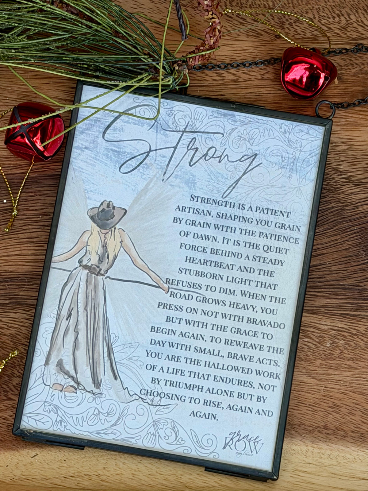 Decorative print with a woman holding a sword and text on a wooden surface with decorative elements.